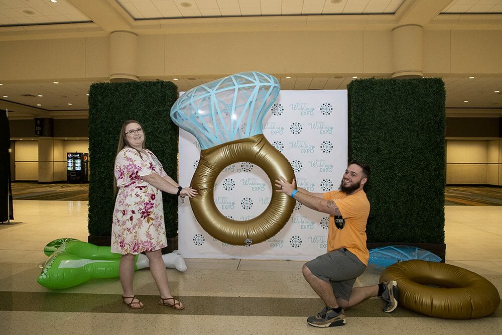 Couple posing with inflatable wedding ring